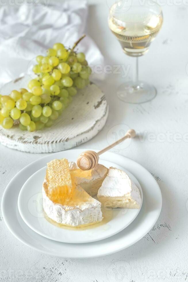 Camembert avec Miel, les raisins et blanc du vin photo