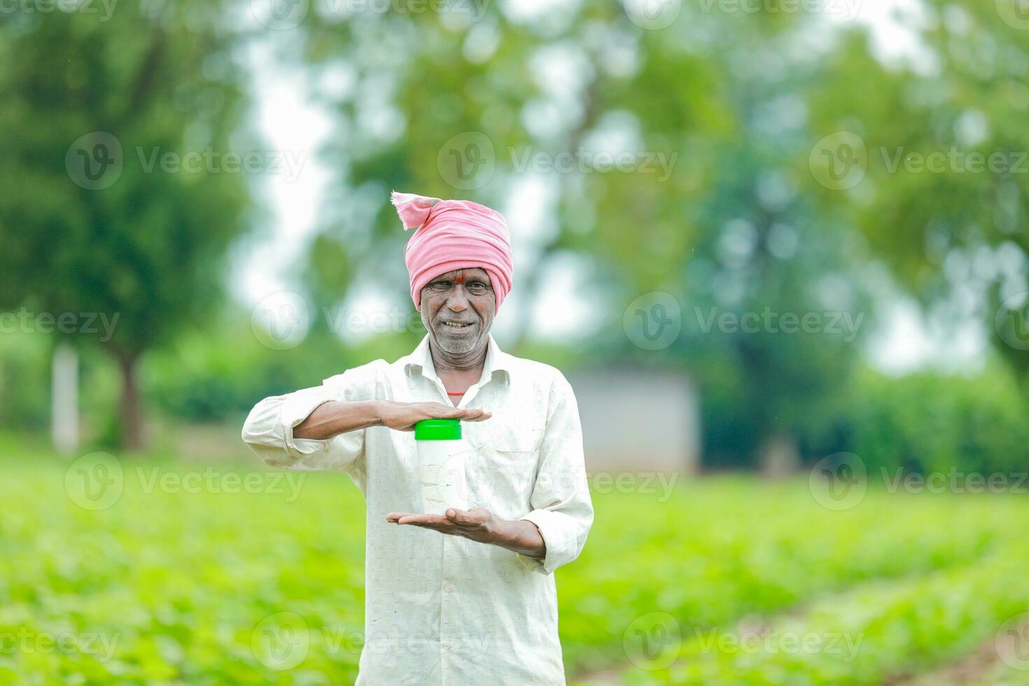 Indien content agriculteur en portant vide bouteille dans mains, content agriculteur montrant blanc bouteille photo