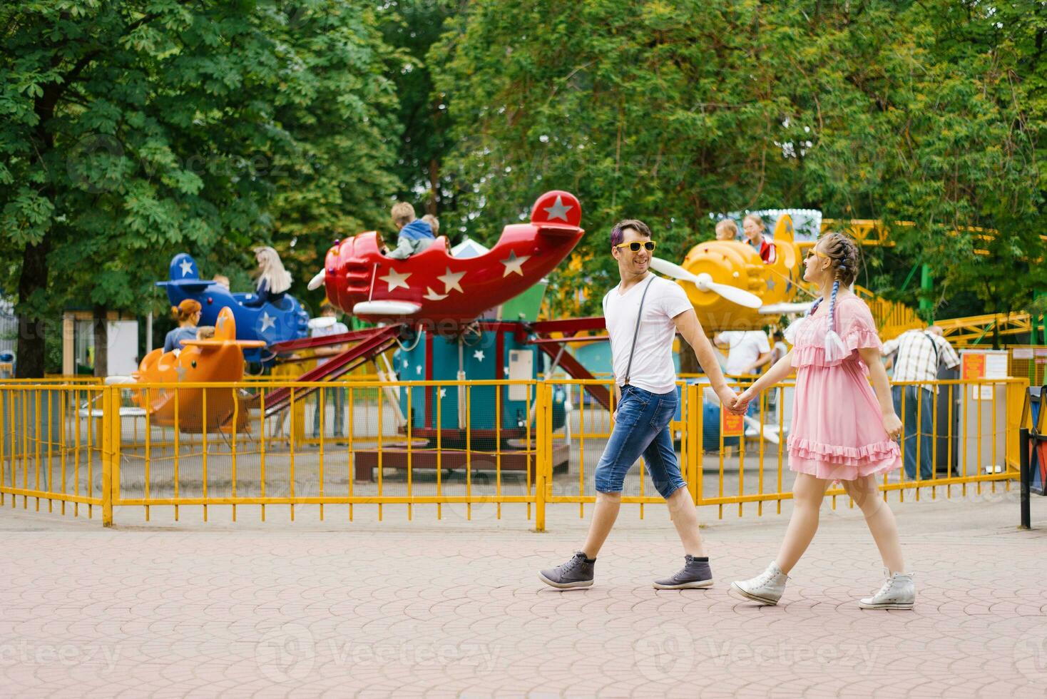 Jeune content couple dans l'amour des promenades et a amusement dans un amusement parc photo