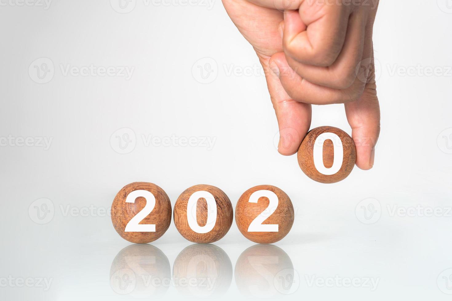 mettre la main sur une boule en bois avec le concept word 2020 photo