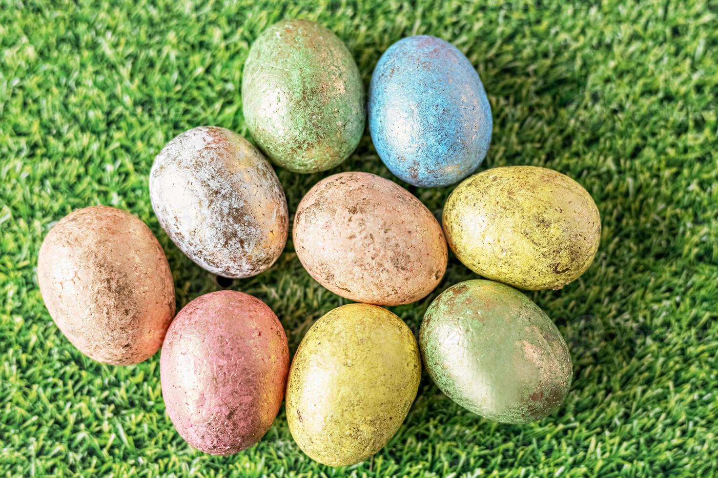 oeufs de pâques aux couleurs pastel sur fond vert avec texture d'herbe. vue d'en-haut photo