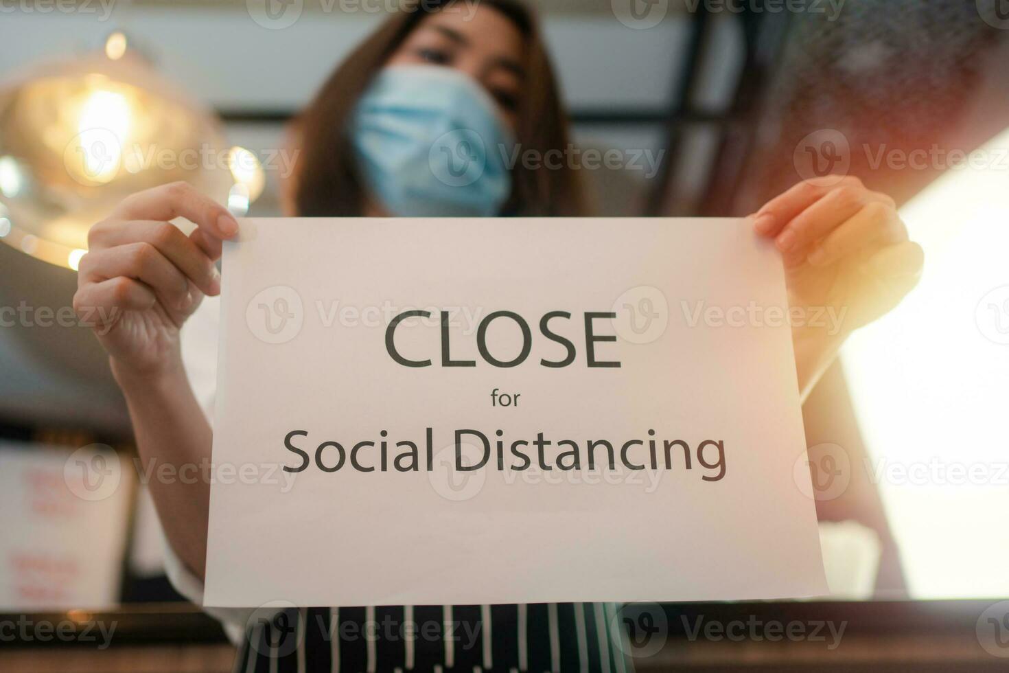 serveuse en portant une signe proche social distanciation dans une café photo