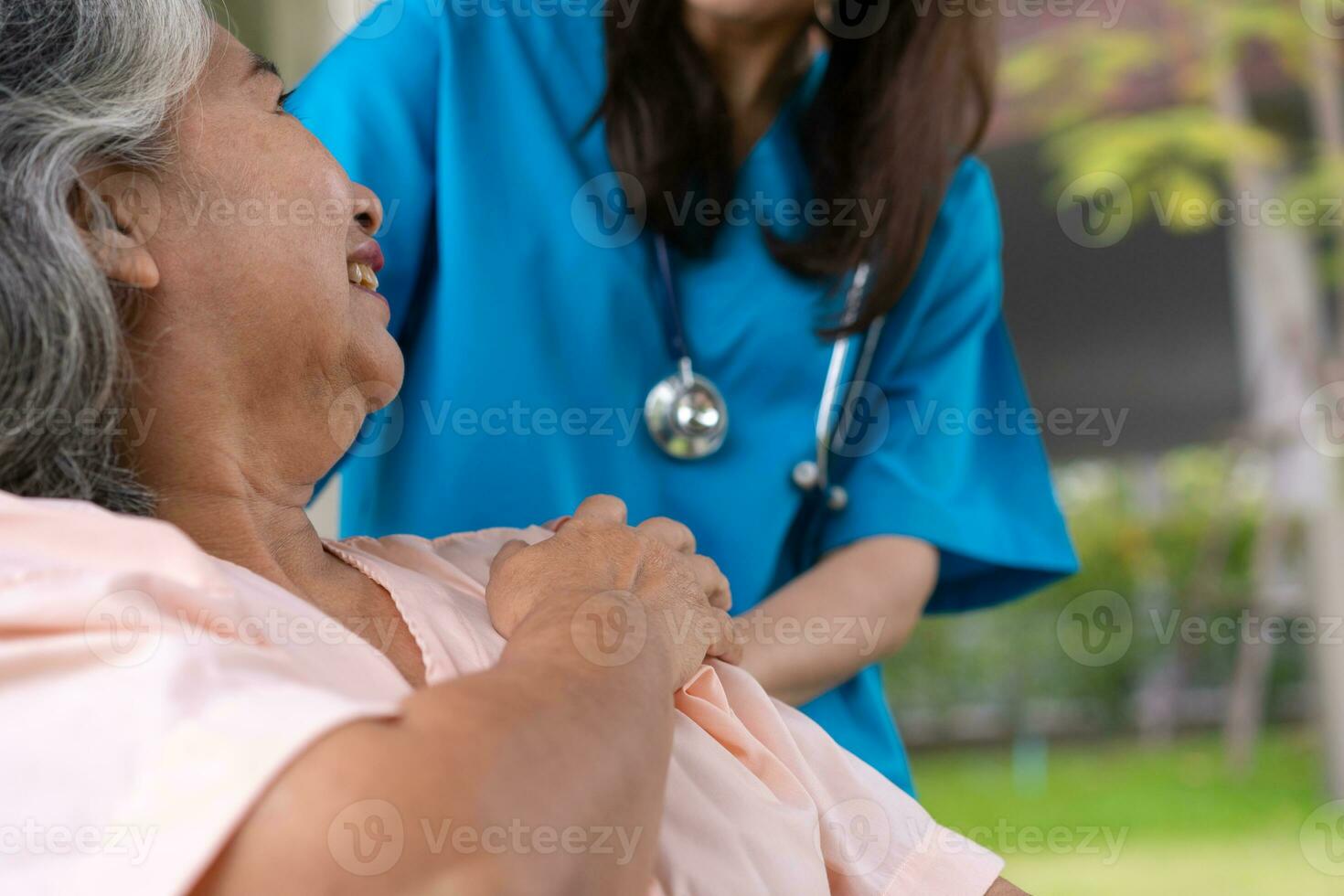 un soignant ou une infirmière asiatique prudente tient la main du patient et encourage le patient en fauteuil roulant. concept de retraite heureuse avec les soins d'un soignant et l'épargne et l'assurance maladie senior. photo