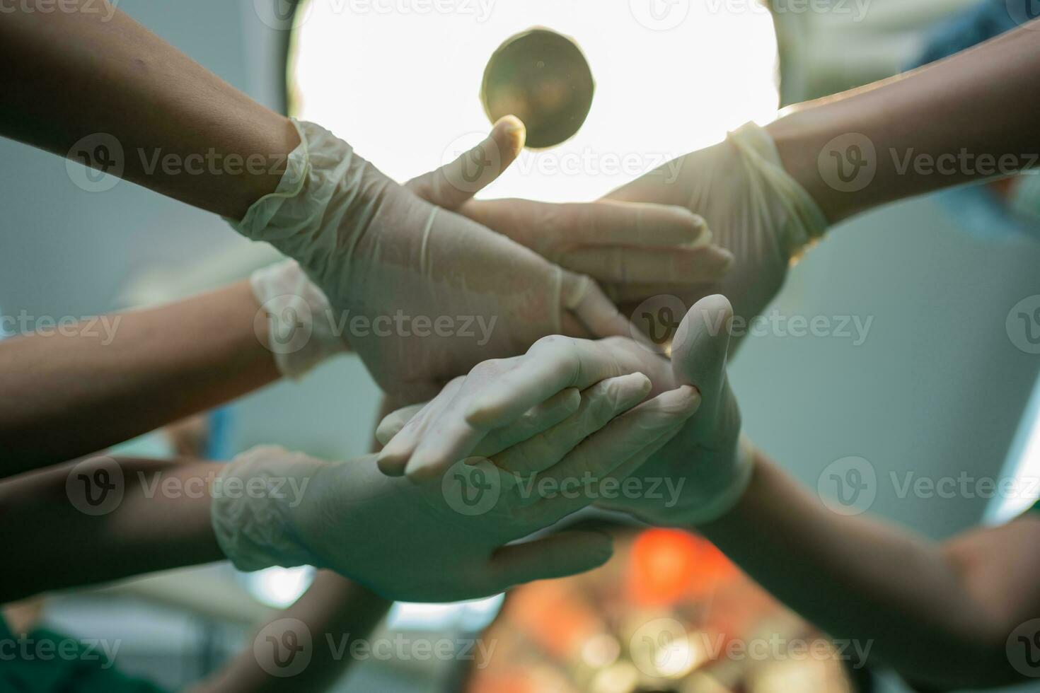 asiatique chirurgien et infirmière avec médical masque permanent et joindre main dans opération théâtre à une hôpital. équipe de professionnel chirurgiens. soins de santé, urgence médical un service concept photo