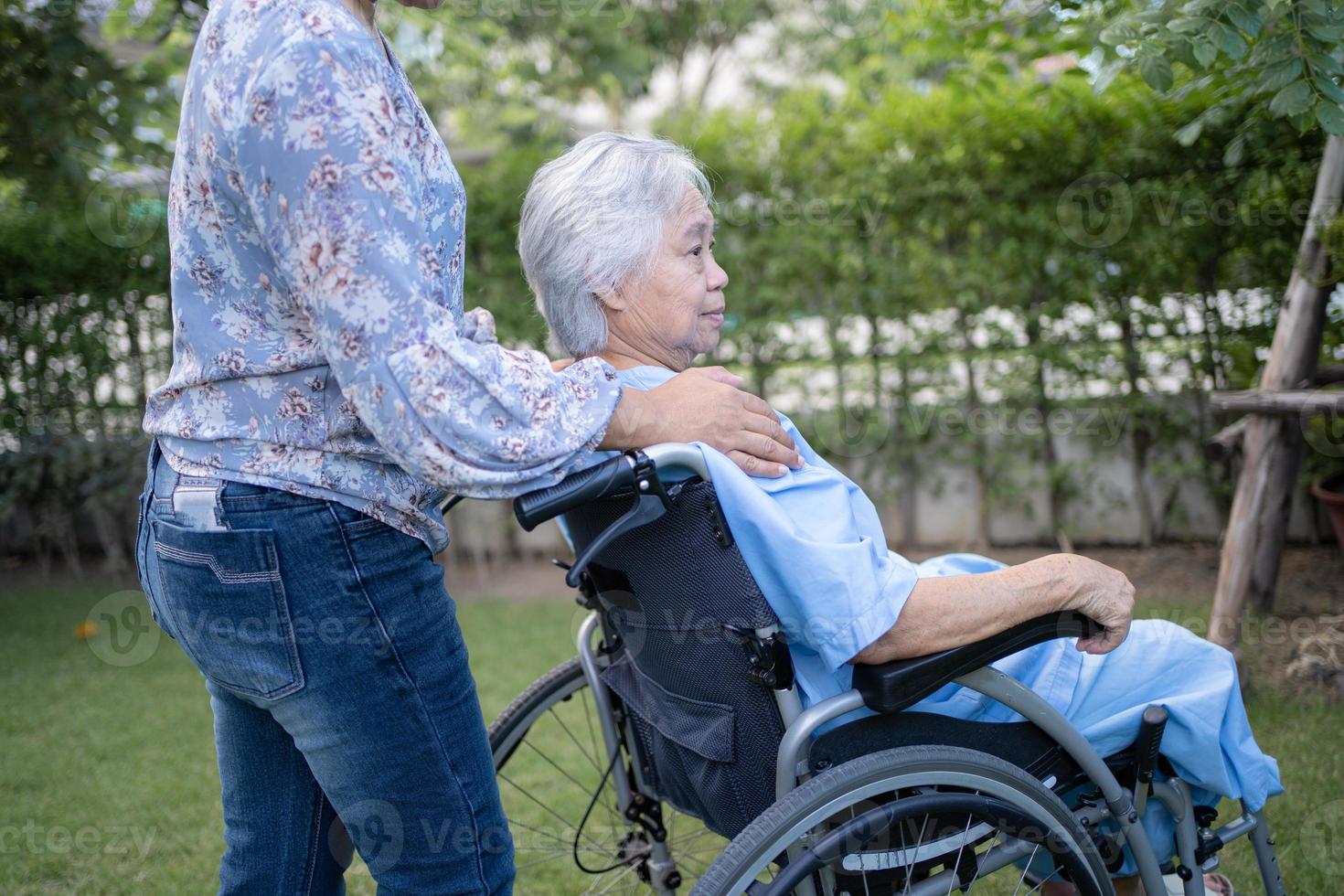 aide d'un médecin et soins d'une patiente asiatique âgée ou âgée, femme assise sur un fauteuil roulant dans un parc de l'hôpital de soins infirmiers, concept médical solide et sain. photo