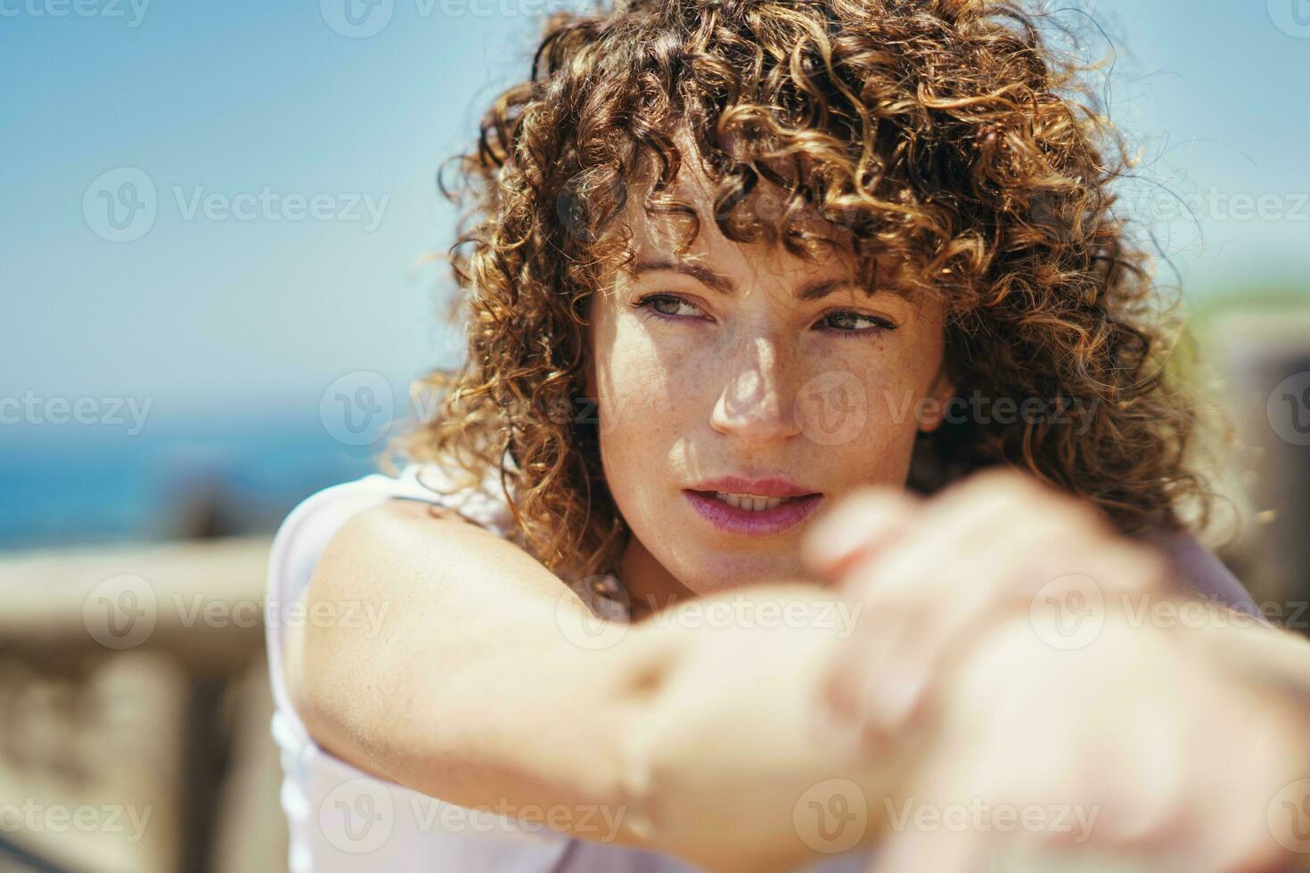 Jeune femme avec frisé cheveux et taches de rousseur sur visage photo