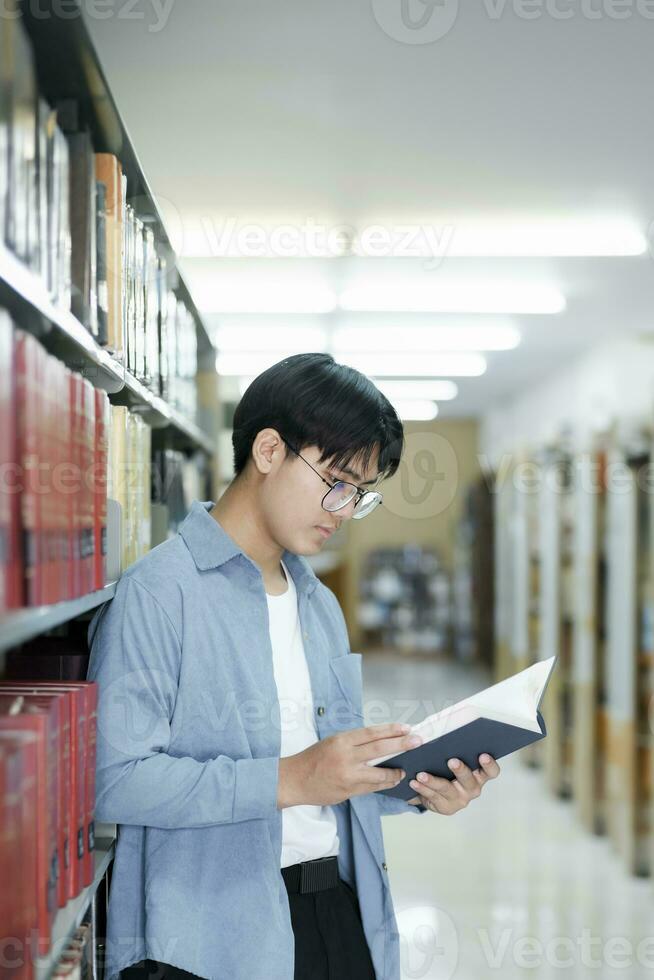 Université élèves en train de lire livres dans bibliothèque pour recherche. photo