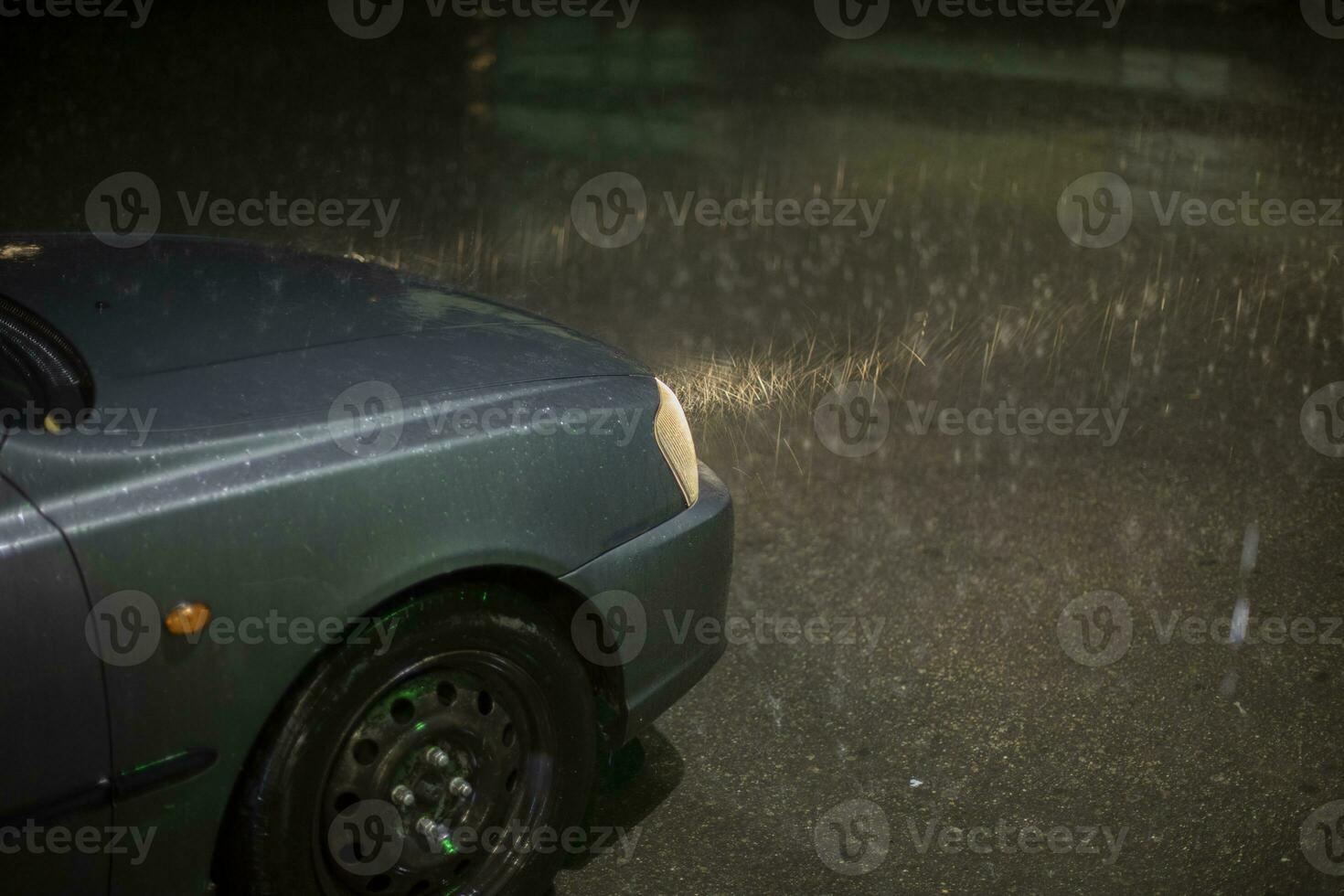 voiture dans pluie. lampe de voiture brille par gouttes de pluie. voyage à nuit dans tempête. photo