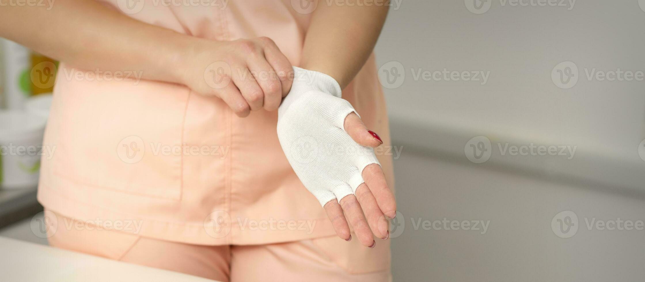 cosmétologue dans vêtements de travail portant blanc bambou sans doigts gants sur sa mains. photo