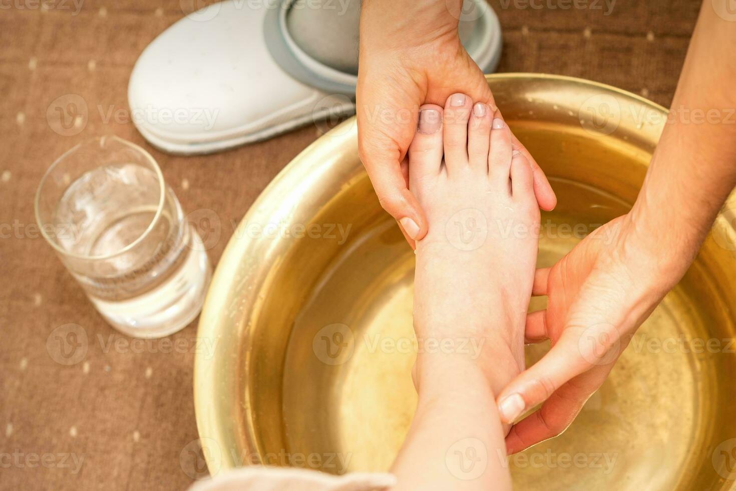 la lessive femelle pied dans une spécial récipient par Masculin masseur dans spa salon. photo