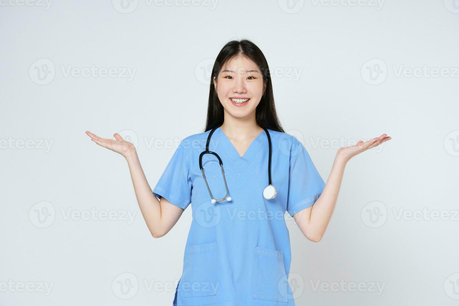 Jeune médecin femme portant une stéthoscope et montrant ouvert main paume avec copie espace pour produit isolé sur blanc Contexte. photo