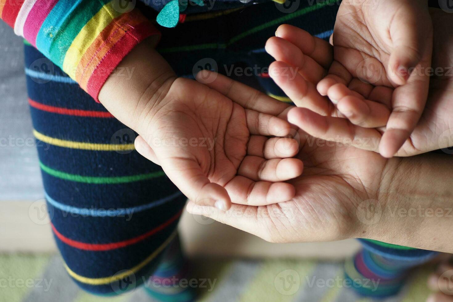 mère en portant main de bébé enfant, photo
