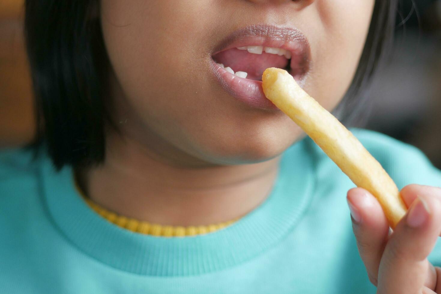 enfant en mangeant français frites proche en haut photo