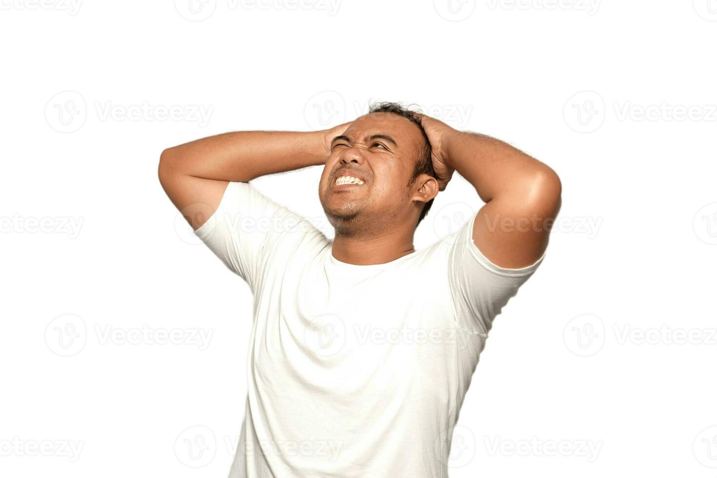 une photo de une asiatique homme stressé deux mains en portant stress tête portant une blanc T-shirt isolé par blanc Contexte. regards déprimé