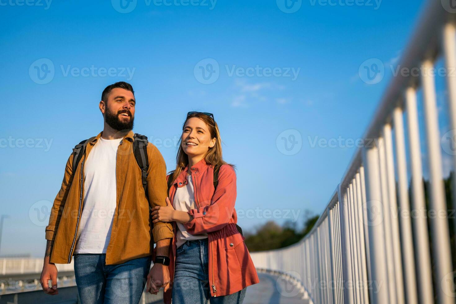 content couple en portant mains et en marchant sur piéton passerelle. touristes sont tourisme dans le ville. photo