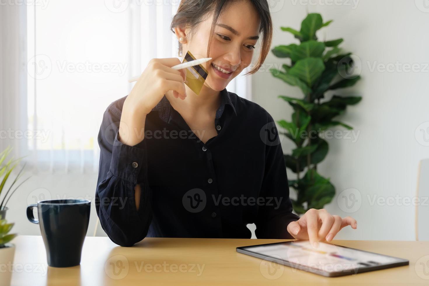 jeune femme utilisant une tablette pour faire des achats en ligne photo