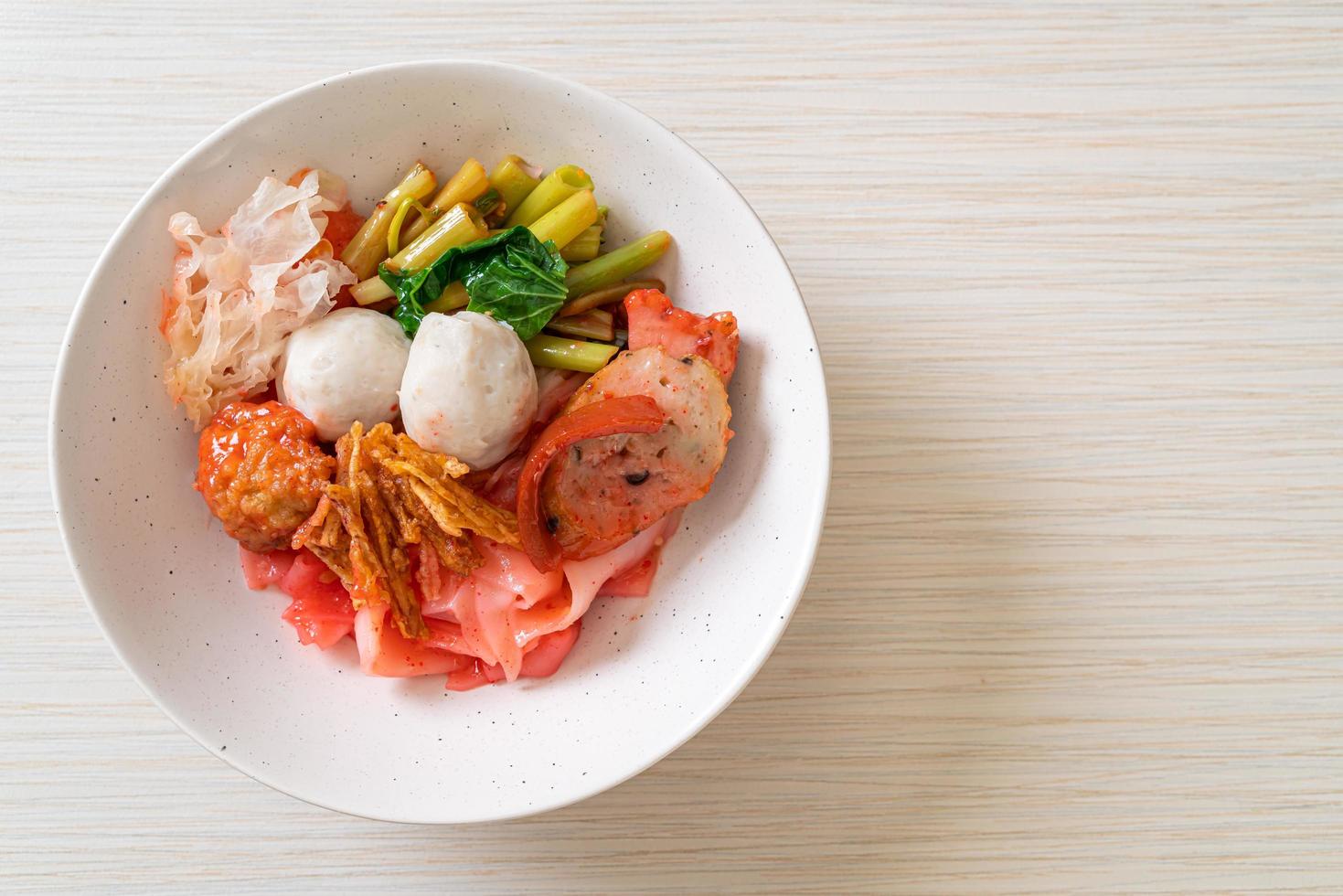 yen-ta-four - nouilles sèches de style thaï avec assortiment de tofu et boule de poisson dans une soupe rouge photo