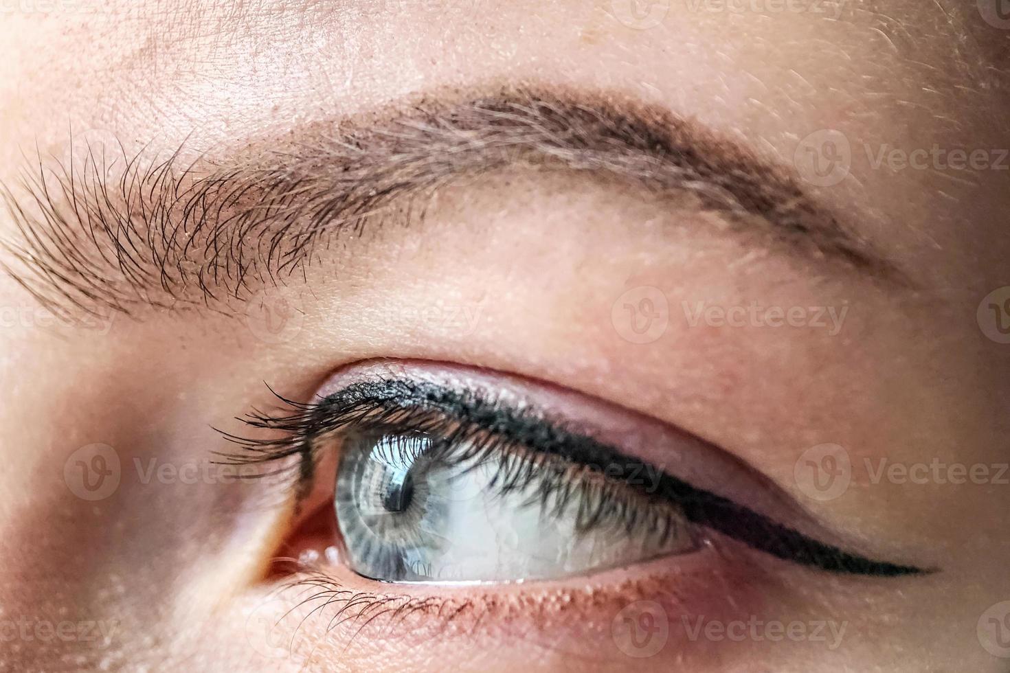 oeil féminin de couleur bleue d'un gros plan de jeune fille. maquillage des yeux et des sourcils.maquillage permanent pour les paupières et les sourcils photo