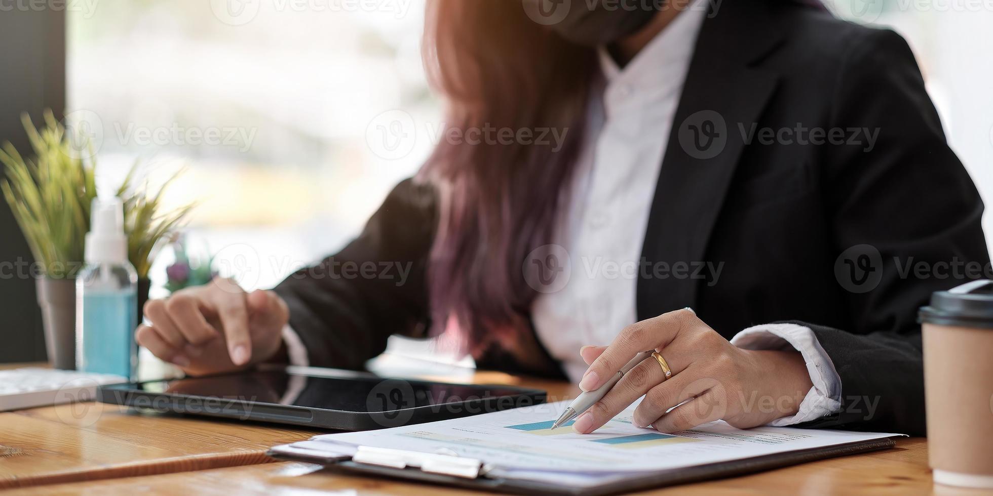 femme d'affaires en gros plan à l'aide d'une calculatrice et d'un ordinateur portable pour faire des finances mathématiques sur un bureau en bois dans un bureau et des antécédents de travail, fiscalité, comptabilité, statistiques et concept de recherche analytique photo