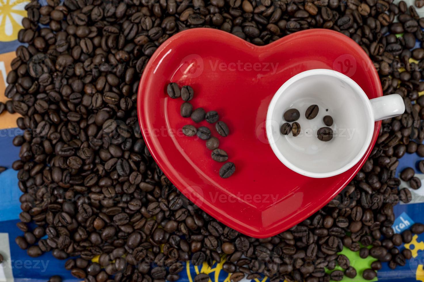 composition de grains de café avec tasse et soucoupe en forme de coeur photo