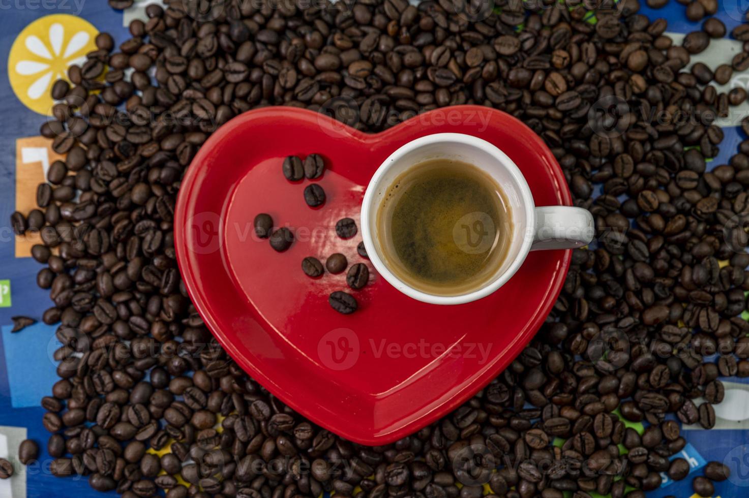 composition de grains de café avec tasse et soucoupe en forme de coeur photo