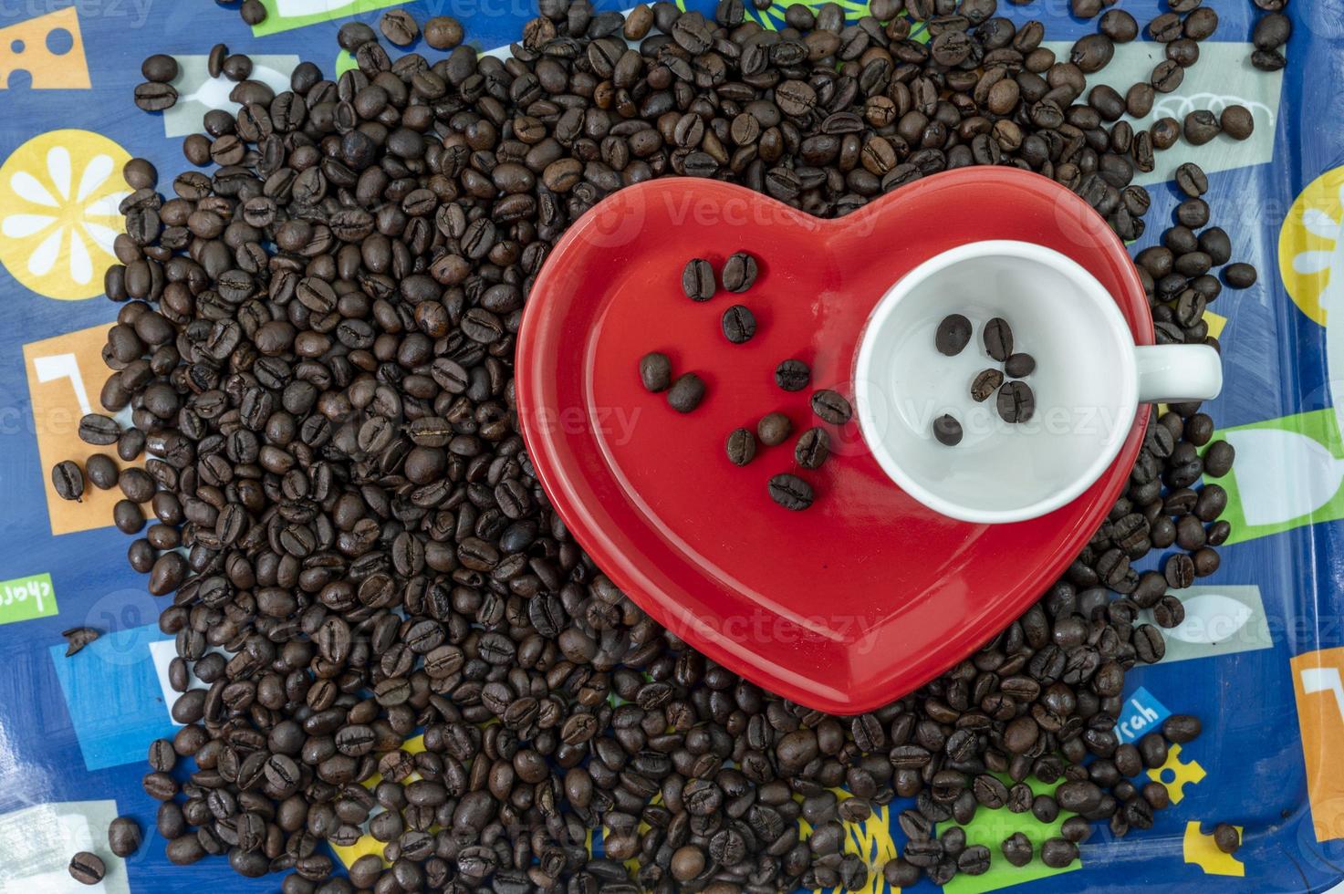 composition de grains de café avec tasse et soucoupe en forme de coeur photo