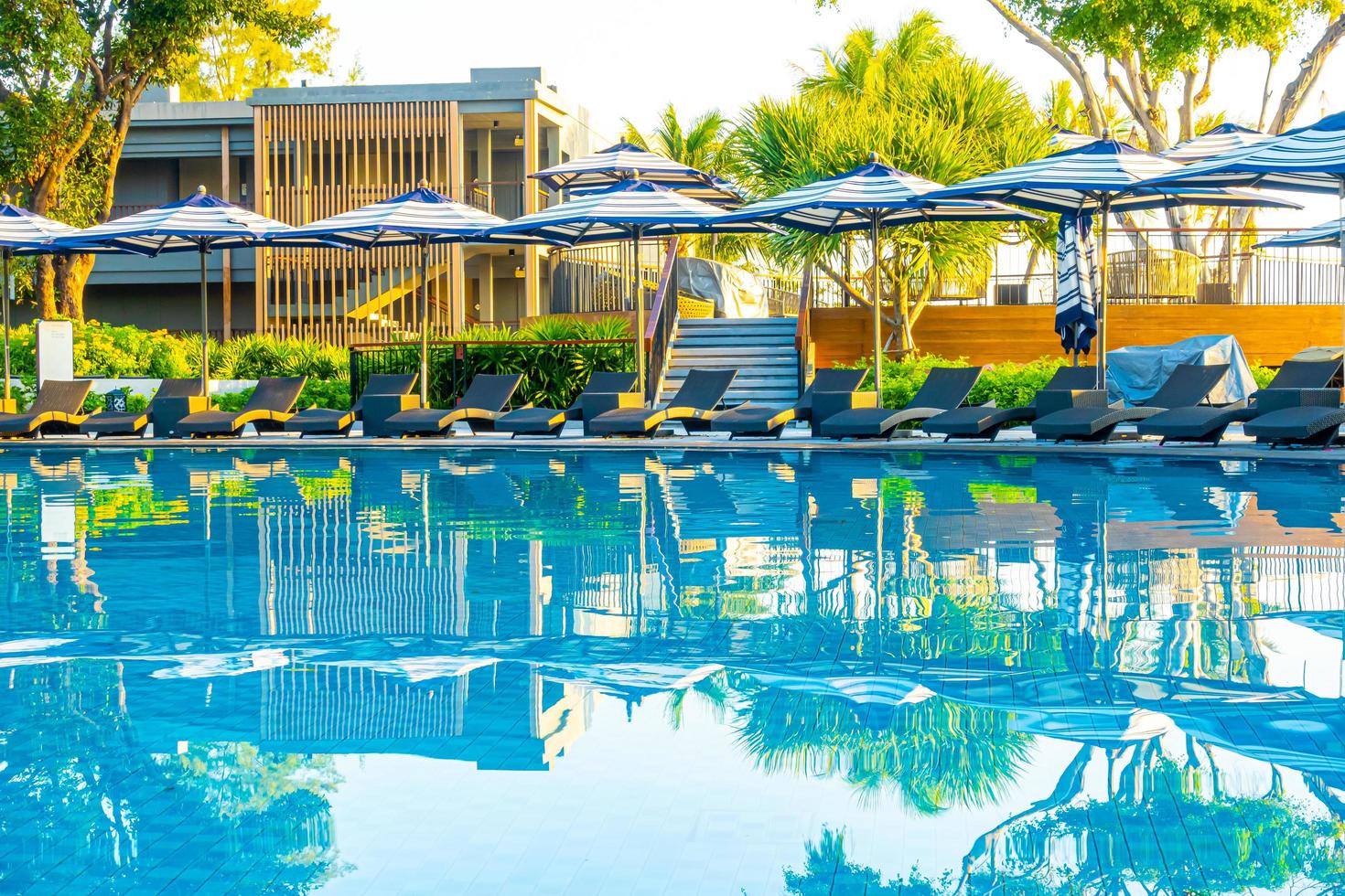 Parasol et lit de piscine autour d'une piscine extérieure dans un complexe hôtelier pour des vacances en voyage photo