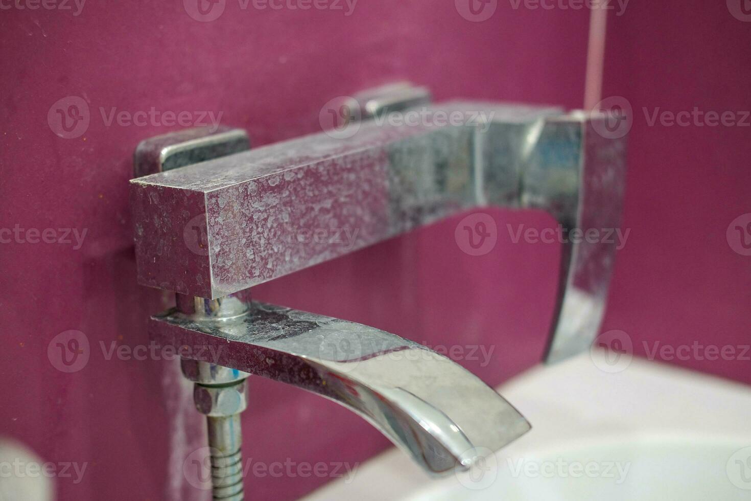 mixer avant appliquant nettoyage agent. sale robinet dans le salle de bains. photo
