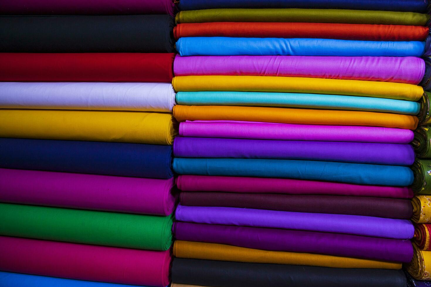 Variété artistique couleurs tons ombre tissus textiles empilés sur l'étagère du magasin de détail à vendre photo