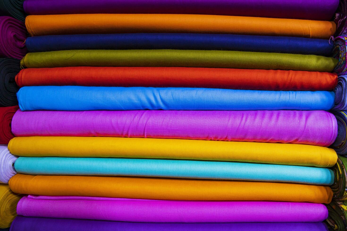 Variété artistique couleurs tons ombre tissus textiles empilés sur l'étagère du magasin de détail à vendre photo