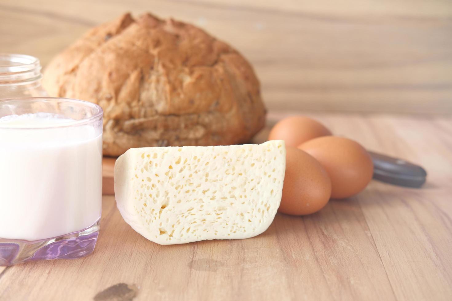 gros plan de fromage, lait, pain brun et noix d'amande sur la table. photo