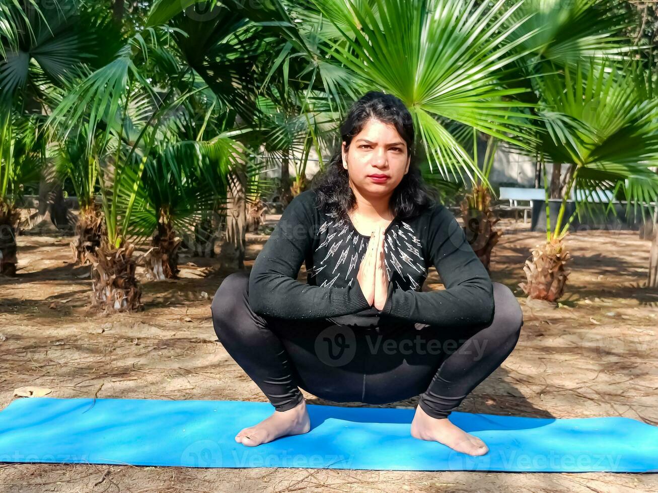 jeune femme indienne pratiquant le yoga en plein air dans un parc. belle fille pratique la pose de yoga de base. calme et détente, bonheur féminin. poses de yoga de base en plein air photo