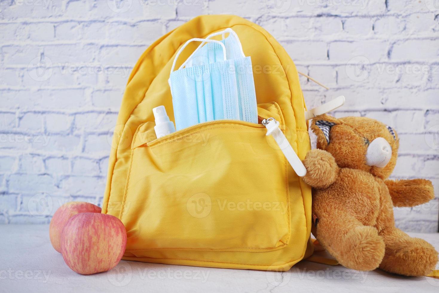 sac d'école étudiant avec désinfectant, un masque facial. photo