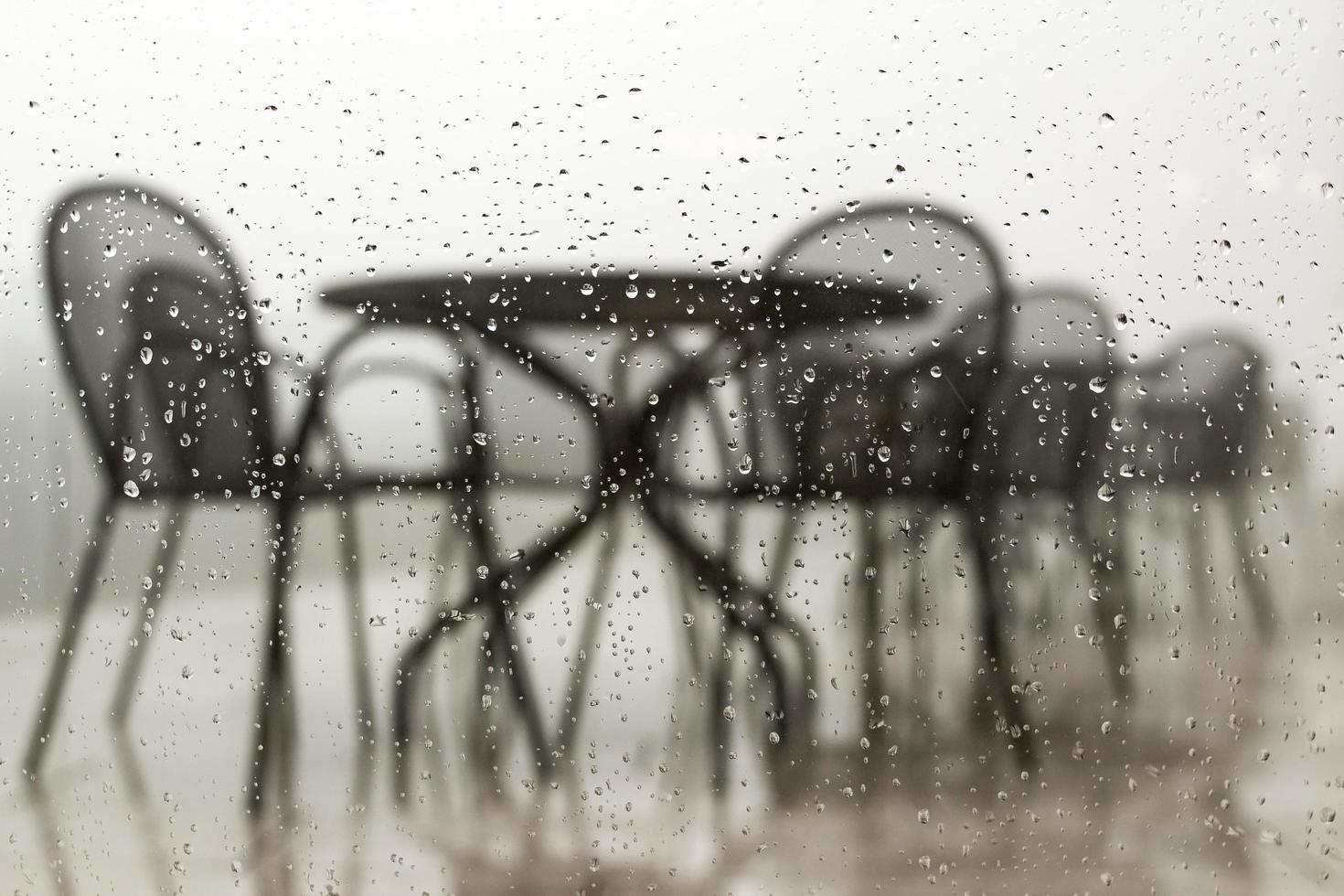 gouttes d'eau sur la fenêtre en verre terrasse du restaurant vue à travers la fenêtre avec des gouttes de pluie le jour de pluie mauvais temps fond d'écran photo