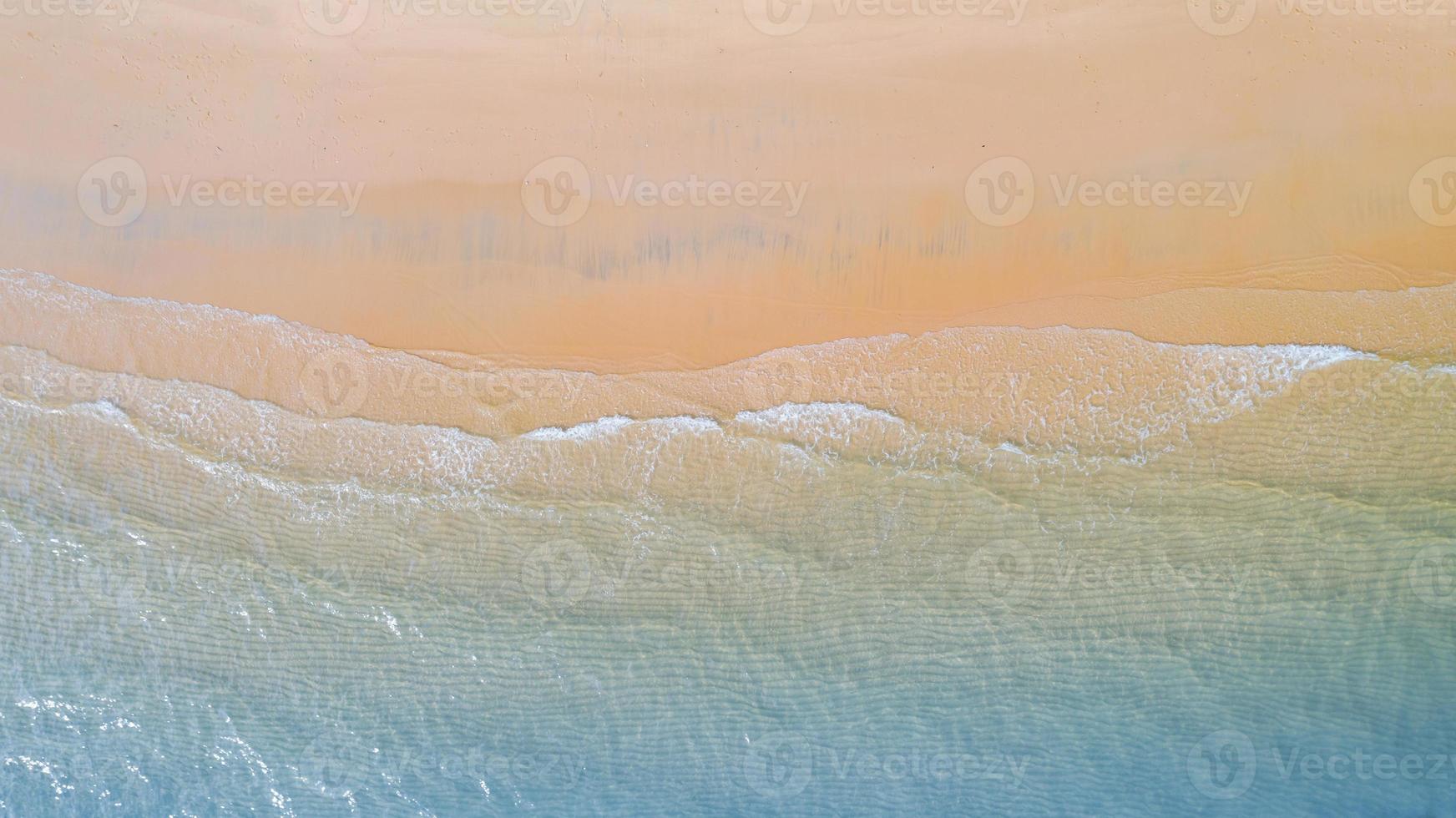 vue aérienne de la plage à l'ombre de l'eau bleu émeraude et de la mousse des vagues sur la mer tropicale photo