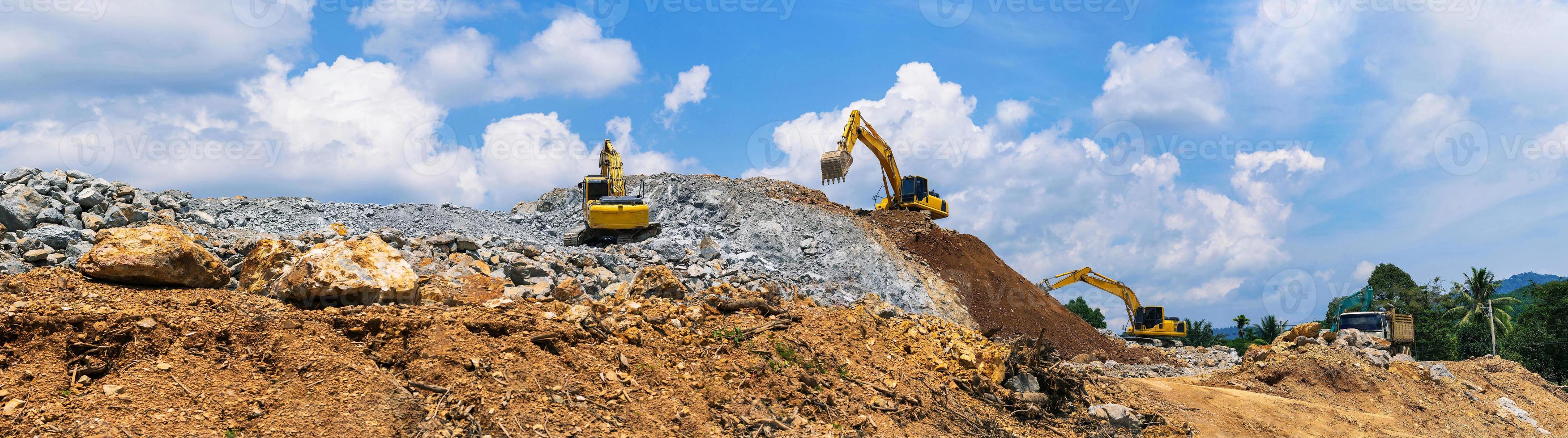 panorama, excavatrices et concasseur de pierres de l'exploitation minière sous un ciel bleu avec des nuages photo