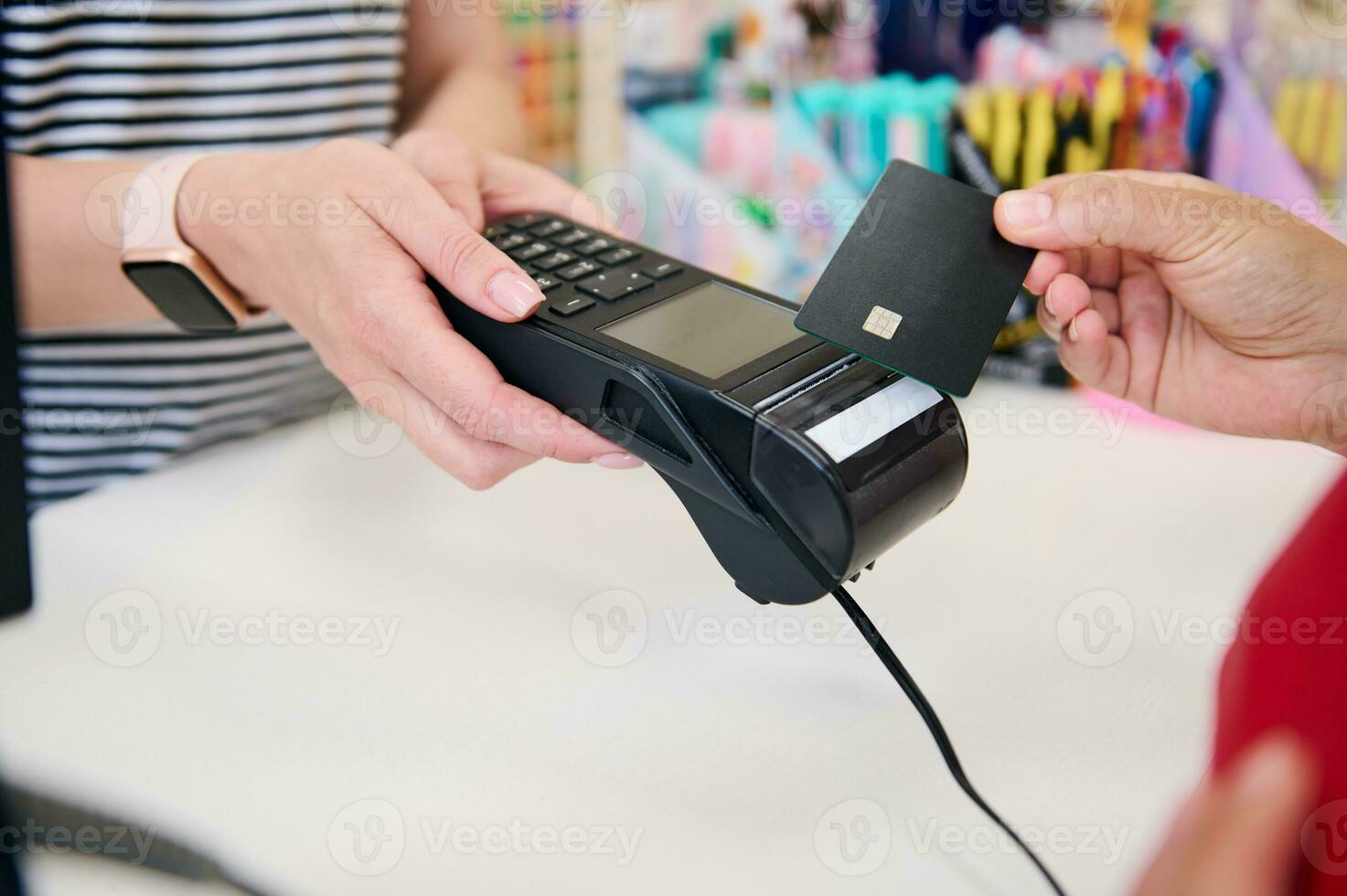 fermer vendeur dans une boutique avec une pos Terminal tandis que une client balayages une crédit carte et fait du sans contact Paiements photo