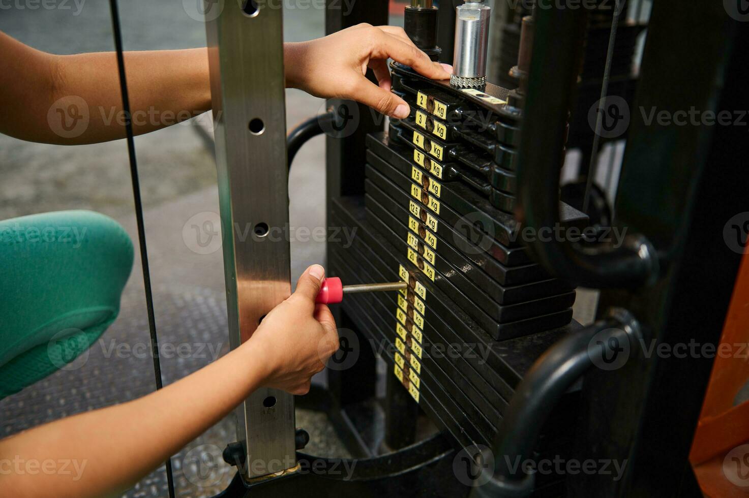 fermer de un méconnaissable athlète réglage poids sur une bloquer Gym équipement photo