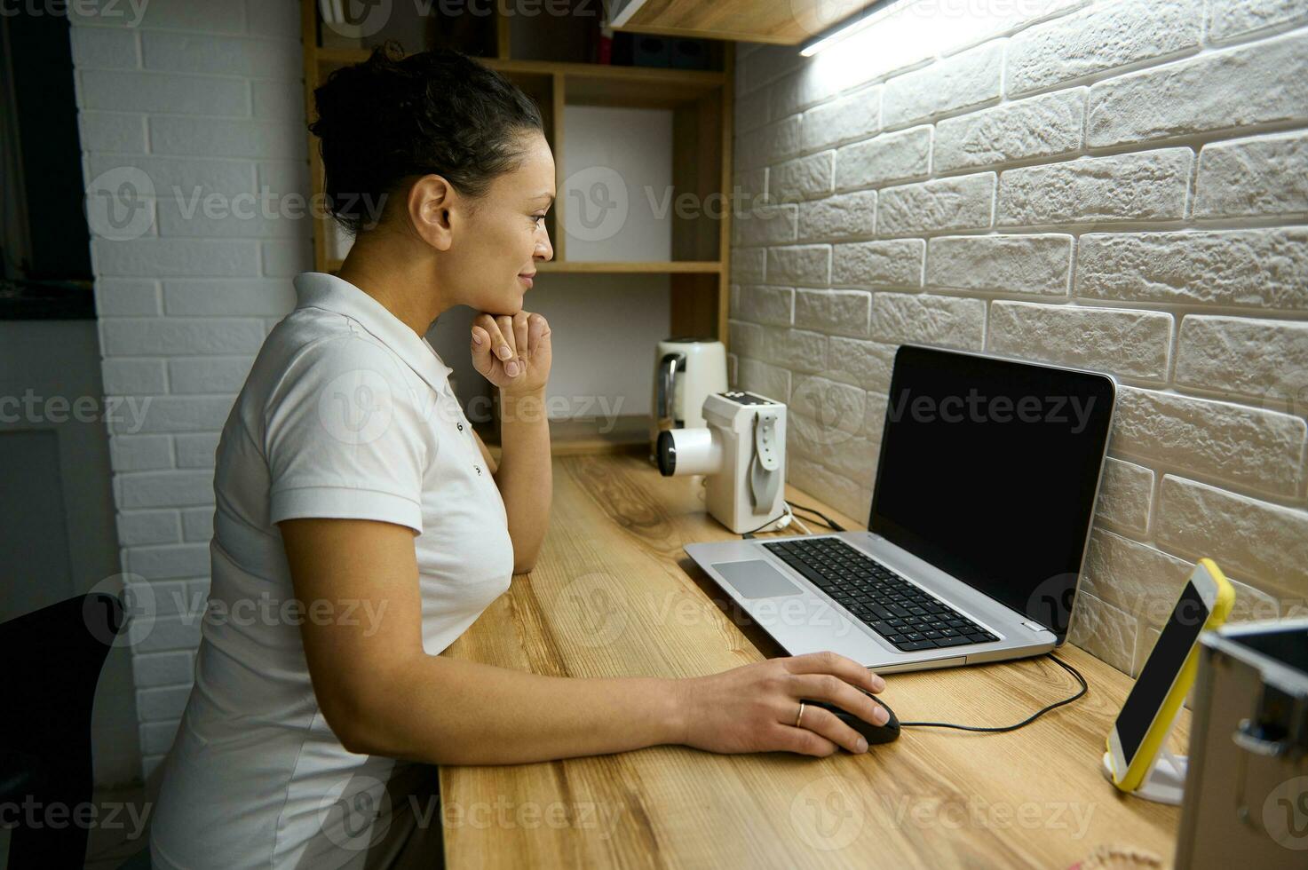 femelle médecin dentiste séance dans de face de une portable avec Vide moniteur écran et consultant une patient sur une vidéo appel à propos le dentaire traitement. en ligne consultation concept dans médical sphère photo