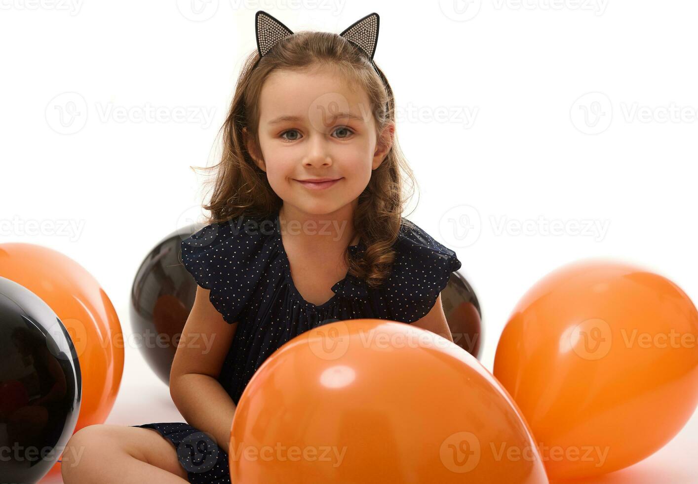 portrait de mignonne 4 ans vieux sorcière fille dans Halloween costume avec coloré noir et Orange des ballons isolé sur blanc Contexte avec copie espace. Halloween faire la fête. photo