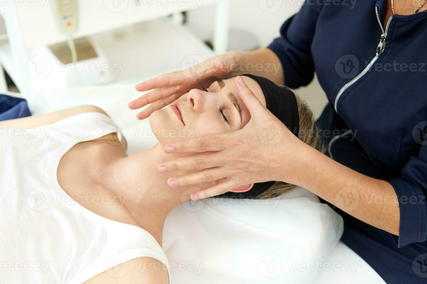 esthéticienne performant professionnel faciale massage sur femme visage à spa clinique photo