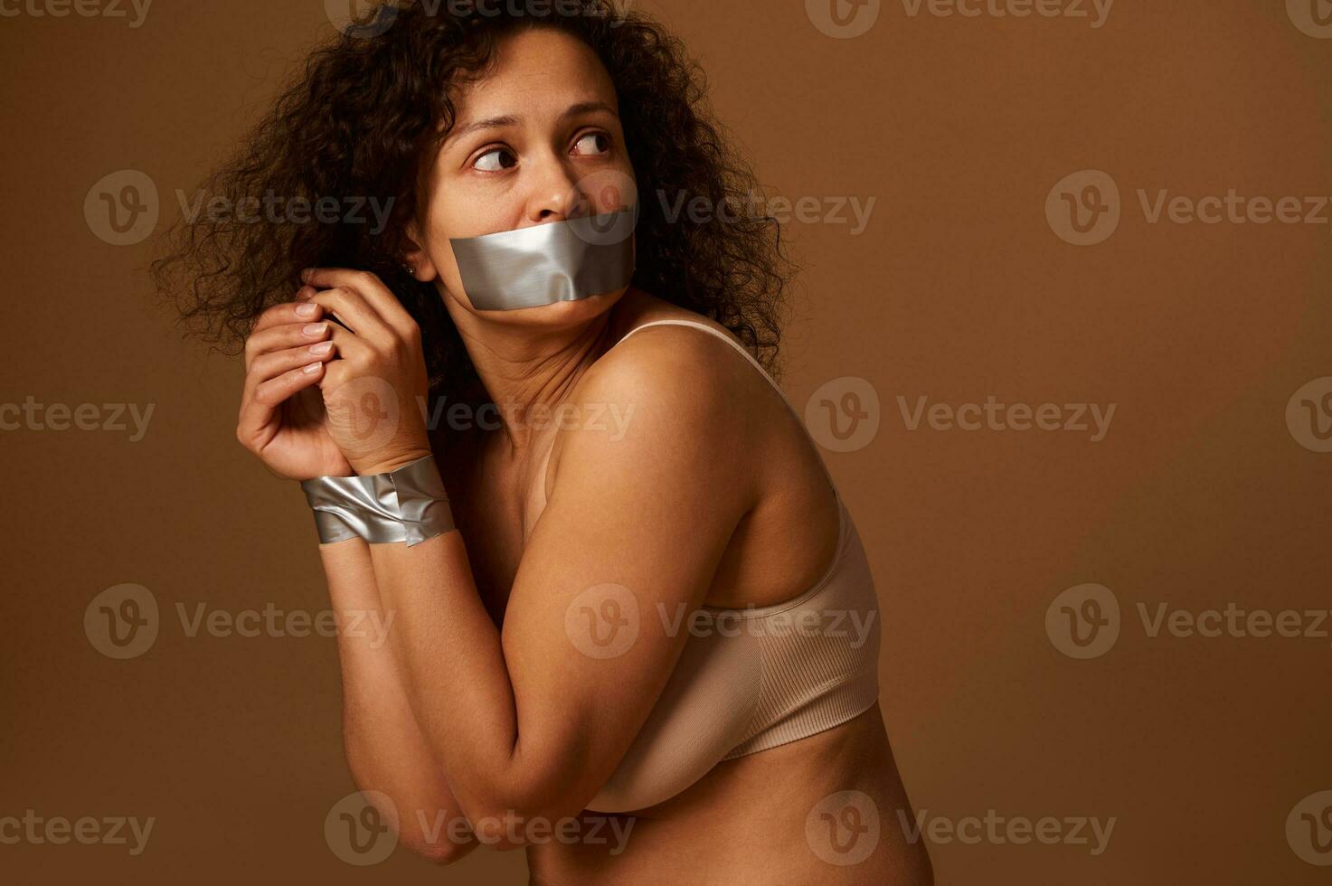 proche en haut portrait de effrayé désespéré femme avec sa bouche fermé et sa mains lié, à la recherche retour avec espérer et prier pour Aidez-moi dans fin la violence contre femmes. social concept, foncé Contexte photo