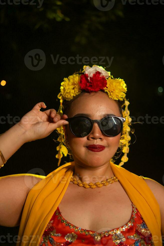 une portrait de un indonésien Danseur avec jasmin balançant dans sa cheveux orne sa magnifique apparence sur étape photo