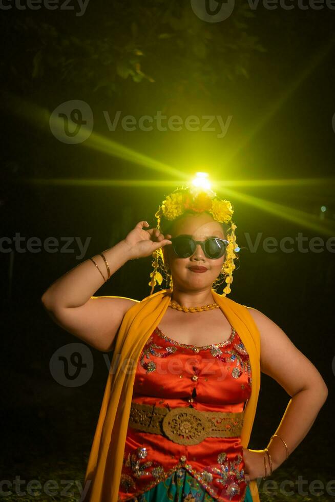 une portrait de un indonésien Danseur avec jasmin balançant dans sa cheveux orne sa magnifique apparence sur étape photo