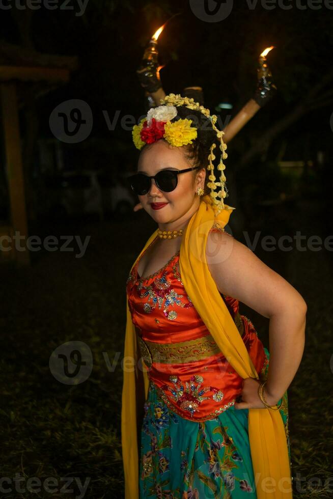 une portrait de un indonésien Danseur avec jasmin balançant dans sa cheveux orne sa magnifique apparence sur étape photo