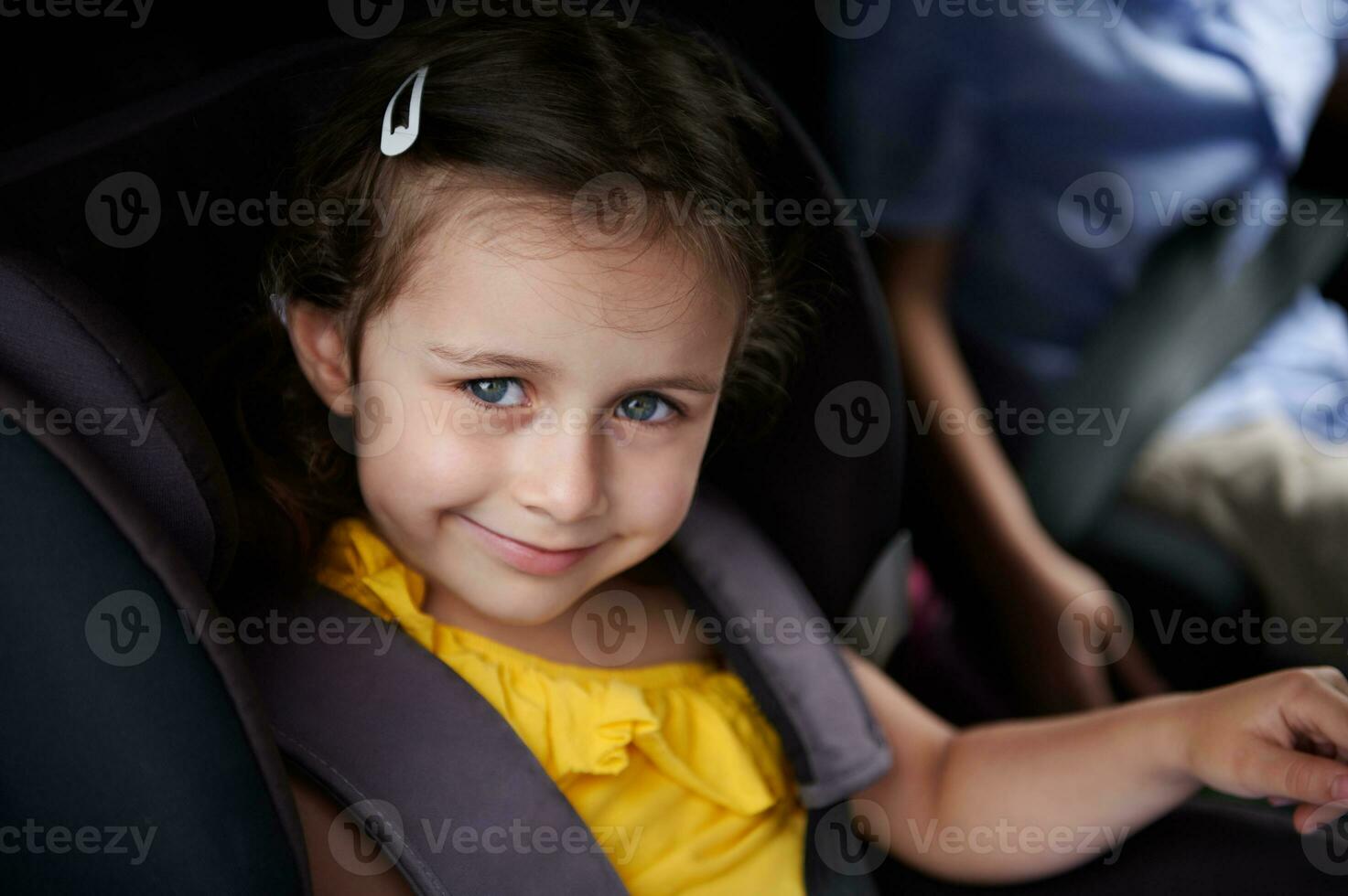 bébé fille ceinturé dans une sécurité enfant voiture siège, sourit