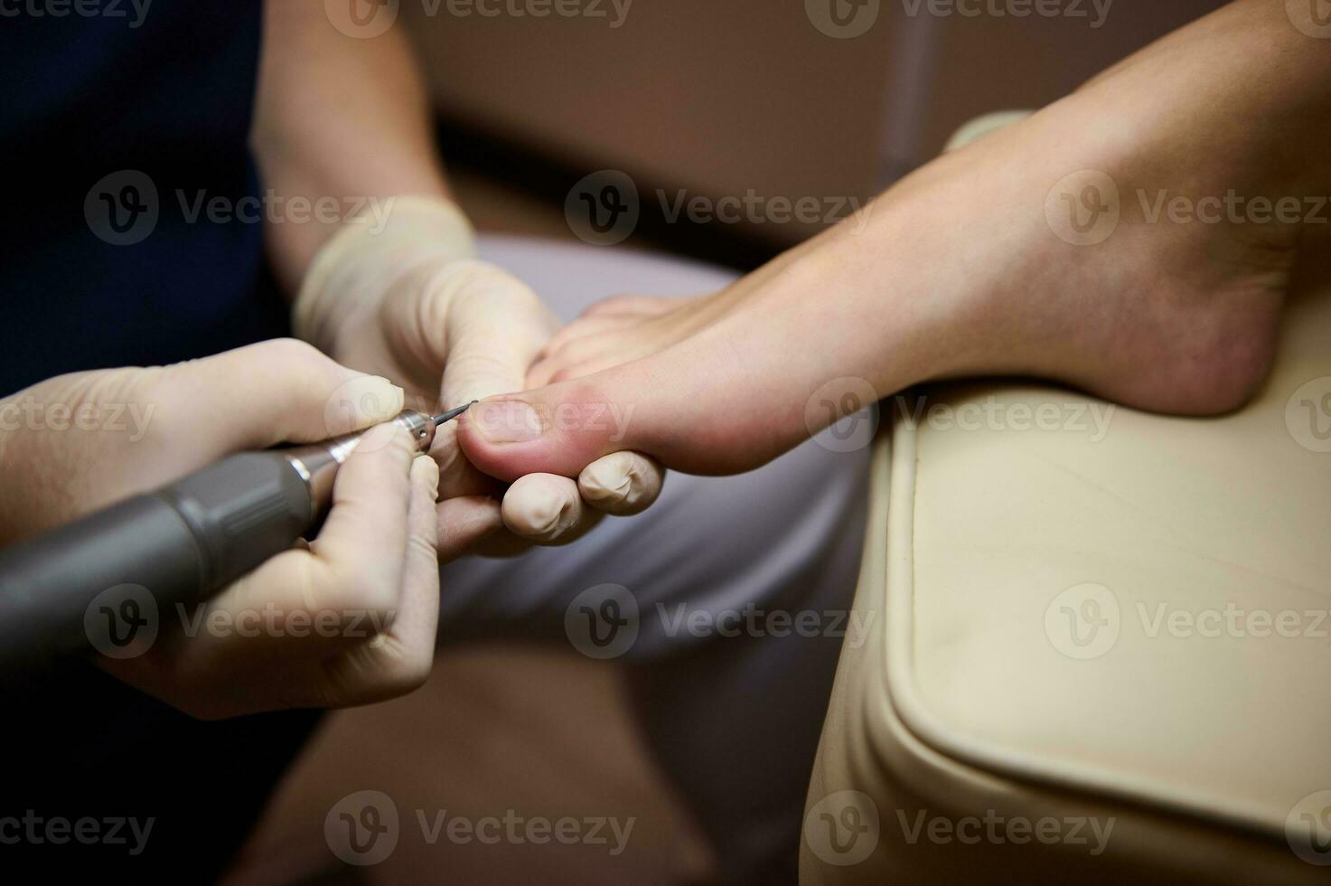 professionnel Matériel pédicure en utilisant électrique machine.patient sur pédicure procédure, visite podiatre.peeling pieds avec spécial électrique appareil.pied traitement dans spa salon.podologie clinique. photo