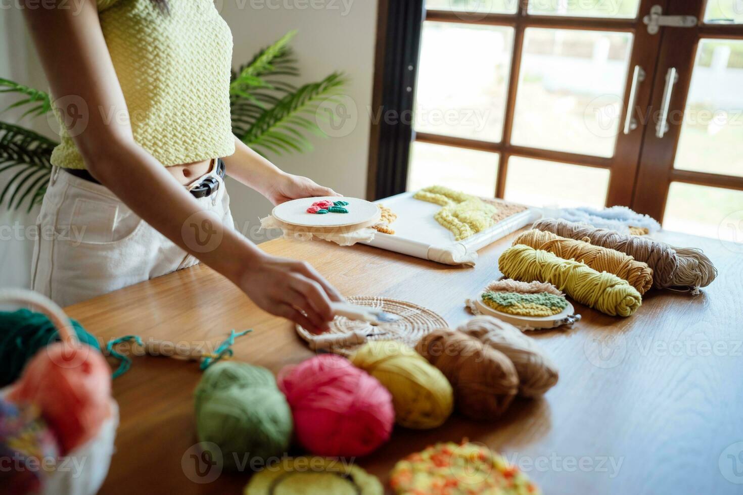 coup de poing aiguille. asiatique femme fabrication Fait main loisir tricot dans studio atelier. designer lieu de travail Fait main artisanat projet DIY broderie concept. photo