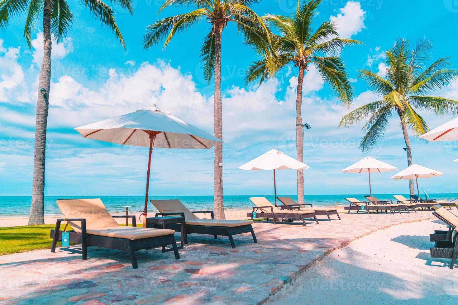 belle plage tropicale et mer avec parasol et chaise autour de la piscine de l'hôtel resort photo