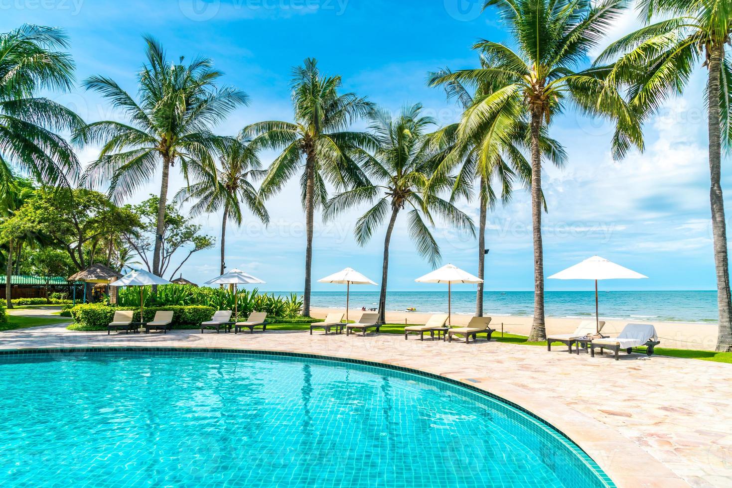 belle plage tropicale et mer avec parasol et chaise autour de la piscine de l'hôtel resort photo